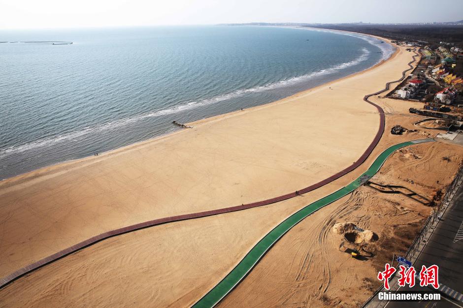 3月13日，秦皇島萬(wàn)米臨海沙灘木棧道。據(jù)了解，該木棧道全長(zhǎng)約4200米，與北戴河區(qū)原有的7500米木棧道對(duì)接后全線(xiàn)總長(zhǎng)度1.17萬(wàn)米，整個(gè)木棧道東起秦皇島體育基地游船碼頭，西至北戴河濕地公園，呈波浪形蜿蜒10.4公里海岸線(xiàn)。 中新社發(fā) 曹建雄 攝 CNSPHOTO